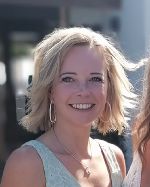 Dargestellt werden Gesicht und Schulterpartie von Frau Cornelia Reisinger. Sie ist blond, träft Kreolen-Ohrringe und ein hellblaues ärmelfreies Shurt.